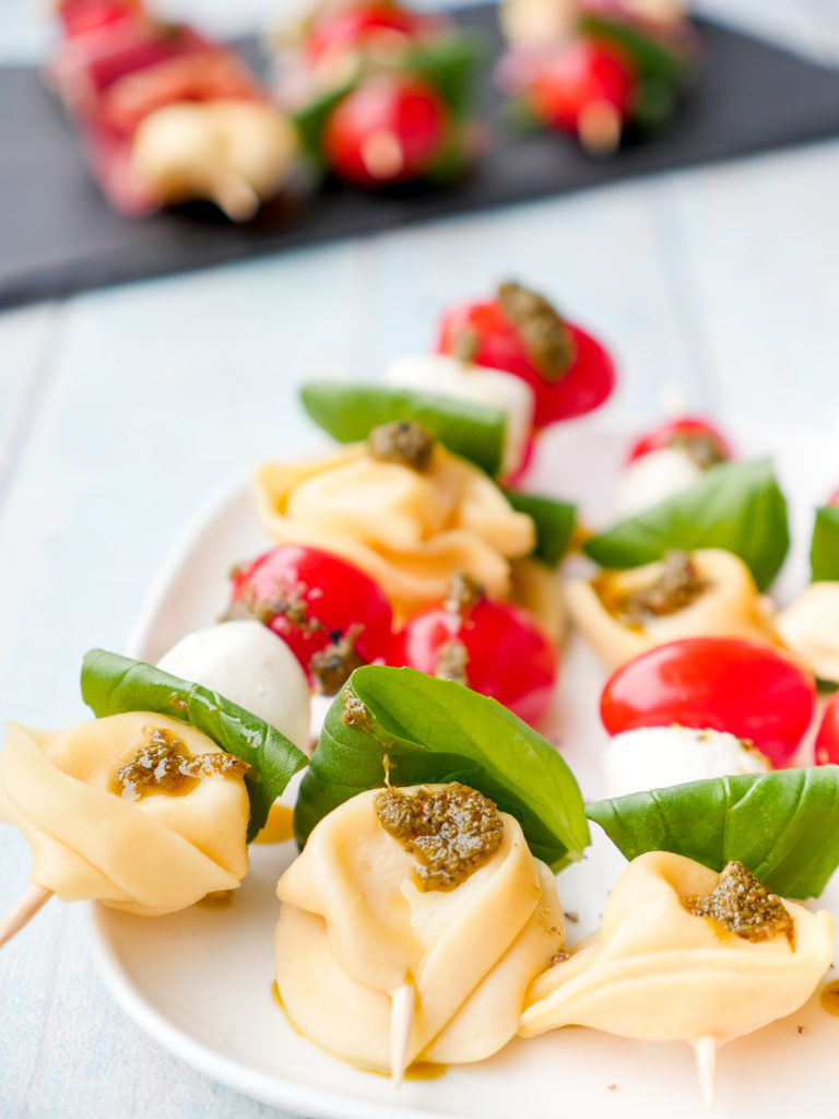  Tortellini salad on a skewer for the New Year's Eve buffet - the colorful skewers with tomatoes, mozzarella and pesto are prepared in a jiffy and a highlight on the buffet TASTEFREUNDIN FOODBLOG #tortellinisalat #tortellini #salat #rezept #schnell #einfach # 6zutaten #partyrecipe 